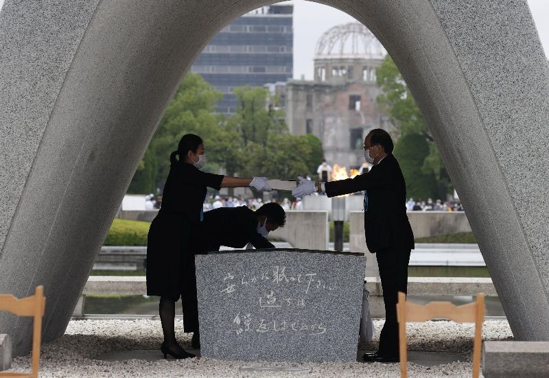 The name list of war dead is given to Hiroshima City mayor Kazumi Matsui from a representative of bereaved families of the 1945 atomic bombing victims at Peace Memorial Park in Hiroshima, western Japan, August 6, 2020, on the 75th anniversary of the atomic bombing of the city.  Kyodo/via REUTERS